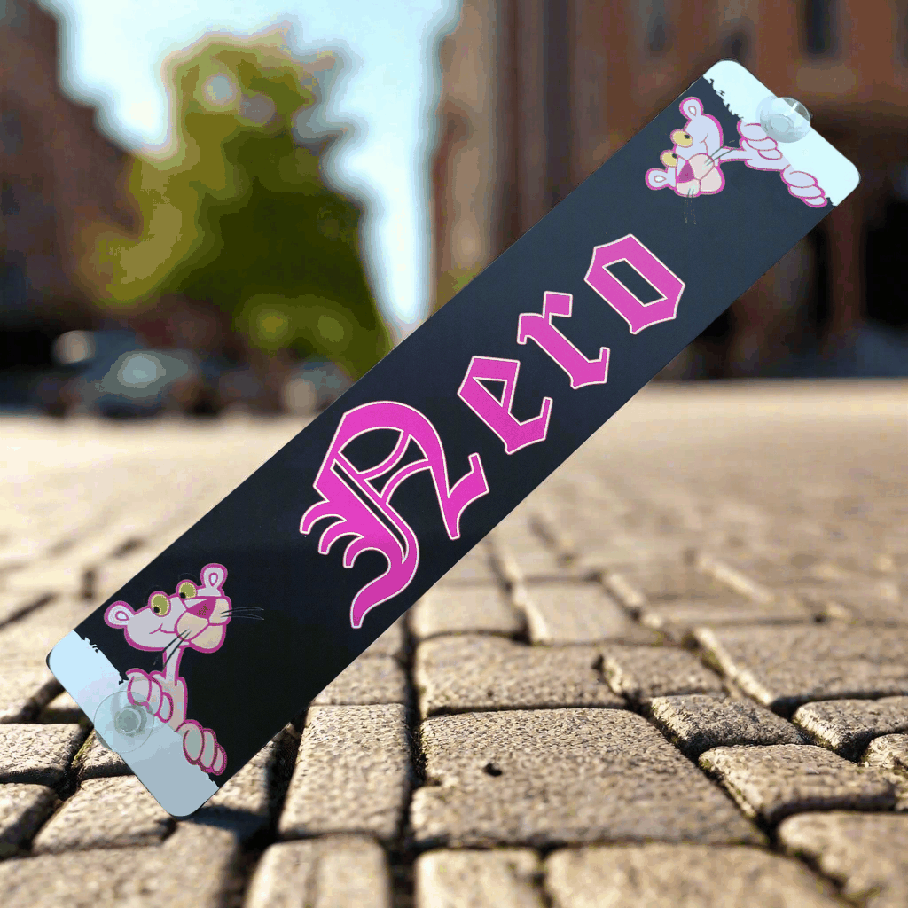 B-Ware LKW-Namensschild 'Nero' mit rosa Details und Saugnäpfen, Abbildung auf gepflasterter Straße.