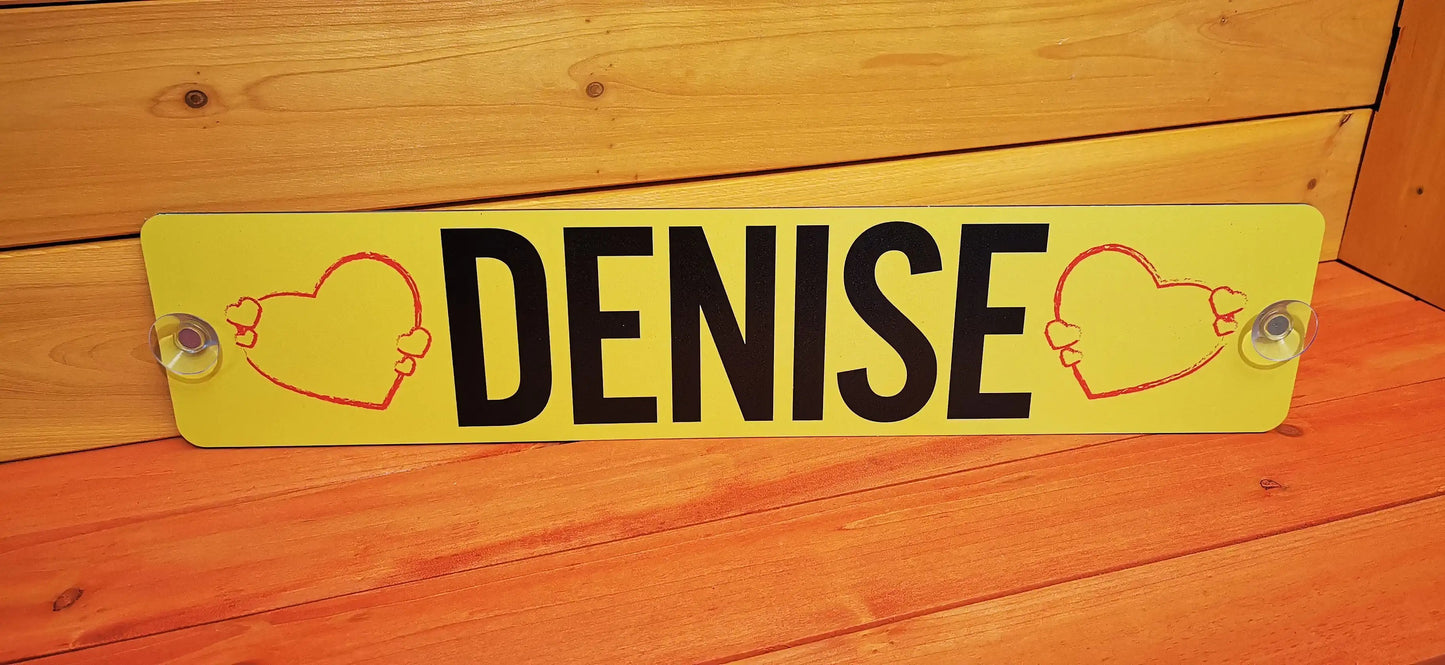 Custom LKW nameplate with 'DENISE' between red heart designs on a yellow background, featuring secure suction mounts.