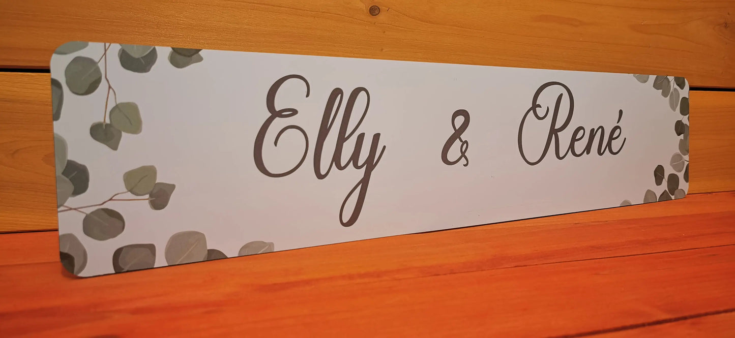 Individually designed wedding car license plate with 'Elly & René' on Alu-Dibond, featuring elegant foliage accents.