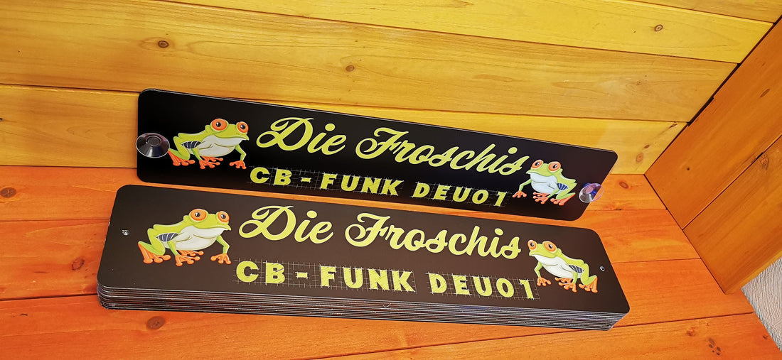 Custom LKW nameplates with frog design and CB-FUNK DEU01 text on a wooden background.
