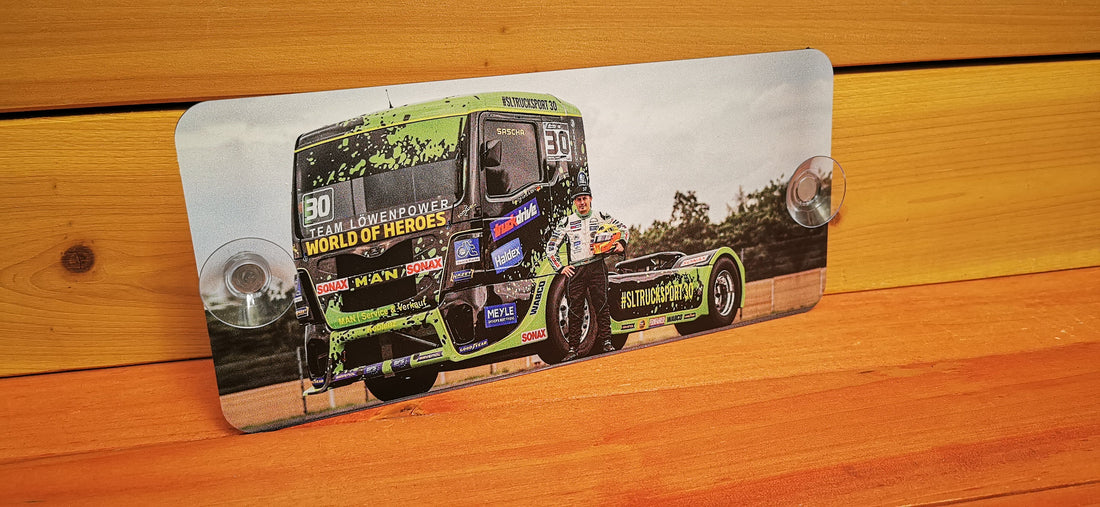 Model truck with racing decals displayed against a wooden background