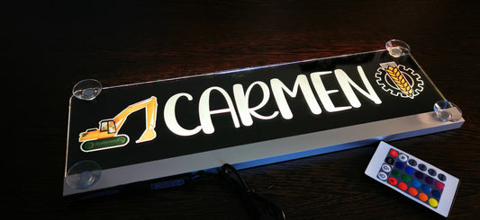 Beleuchtetes LKW Namensschild mit Aufschrift "Carmen" und Fernbedienung auf dunklem Hintergrund