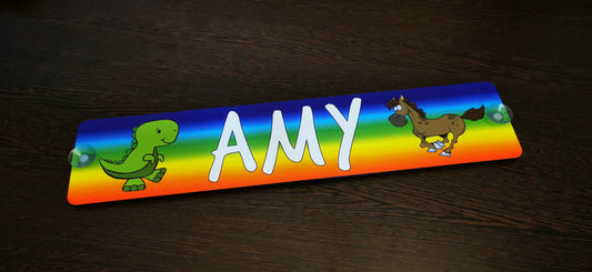 Colorful personalized name plate with "AMY" featuring dinosaur and horse illustrations.