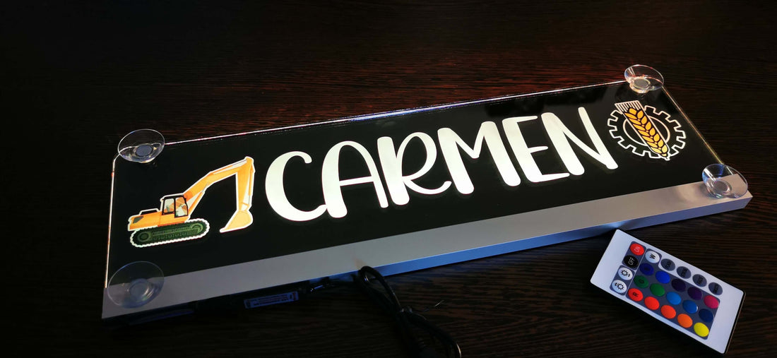 Beleuchtetes LKW Namensschild mit Aufschrift "Carmen" und Fernbedienung auf dunklem Hintergrund