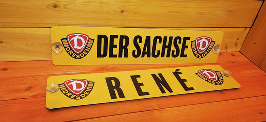 Custom LKW nameplates reading 'DER SACHSE' and 'RENÉ' on a wooden background, personalized by Swetlana - Die Schilderqueen.