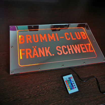 Individuelle LKW Spiegelrückwand mit RGB-LEDs und Wunschmotiv, Fernbedienung sichtbar, personalisiert mit Clubnamen und Ortsbezeichnung