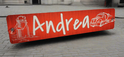 Personalized LKW nameplate with 'Andrea' text and truck motif on red textured background, ideal for vehicle identification.