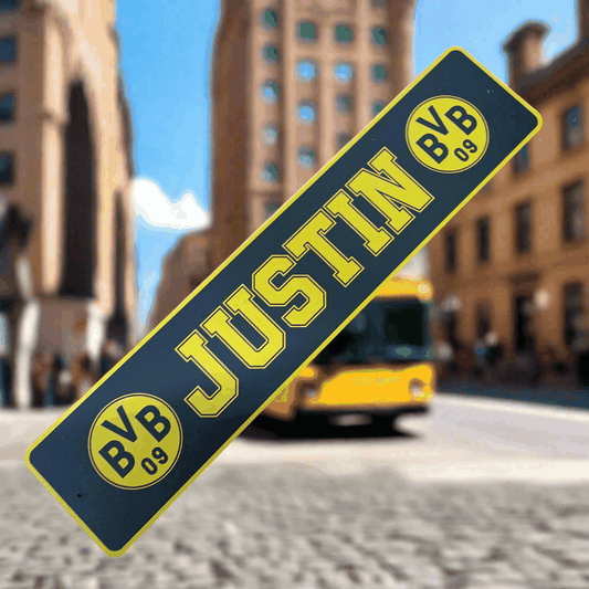 B-Ware LKW-Namensschild 'JUSTIN' in urban setting, yellow and black design, with suction cups for mounting, sale item.