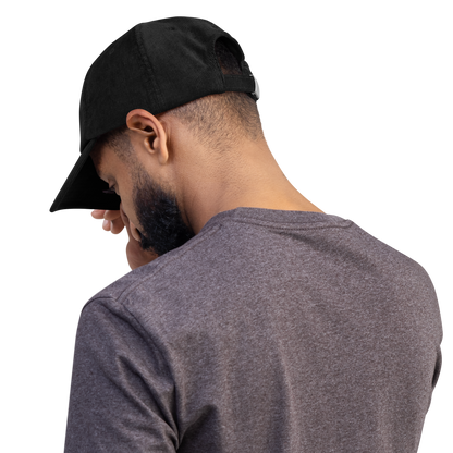 Man wearing a stylish black corduroy cap with intricate cross embroidery, showcasing the cap's comfortable fit and design.
