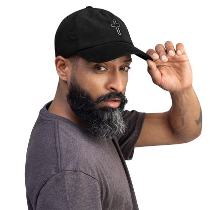 Man wearing a black cord cap featuring a premium cross embroidery, showcasing stylish and durable headwear.