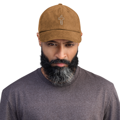 Man wearing a stylish brown cord cap with embroidered cross design, highlighting comfort and durability.
