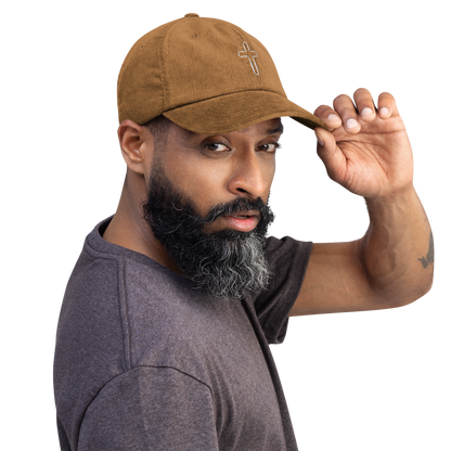 Man wearing brown cord cap with cross embroidery, showcasing stylish and durable design.