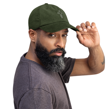 Man wearing green cord cap with high-quality cross embroidery, showcasing comfort and style.
