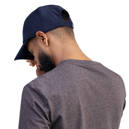 Person wearing a stylish blue corduroy cap with cross embroidery, emphasizing style, durability, and comfort.