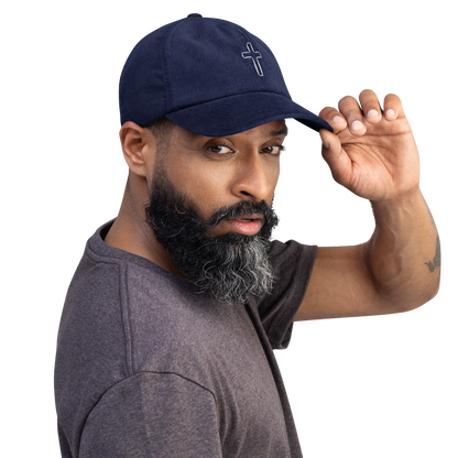 Man wearing navy cord cap with cross embroidery, showcasing a stylish and durable design.