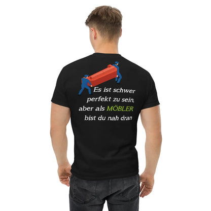 Rückansicht eines Mannes im schwarzen T-Shirt mit witzigem MÖBLER-Spruch und Cartoon, perfekt für Möbel-Enthusiasten.