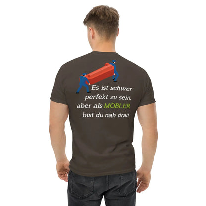 Rückansicht eines Mannes im klassischen Herren-T-Shirt für MÖBLER mit Aufdruck und witzigem Slogan über Perfektion.