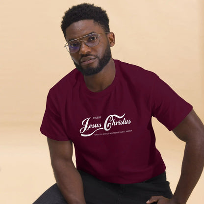 Man wearing maroon T-shirt with 'Erlebe Jesus Christus und du wirst nie mehr Durst haben' printed, showcasing faith and style.