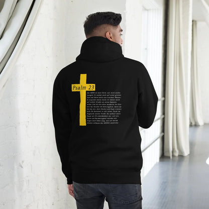 Schwarzer Hoodie mit Psalm 23 Motiv und gelbem Kreuz auf dem Rücken, getragen von einem Model in einem modernen, hellen Raum.