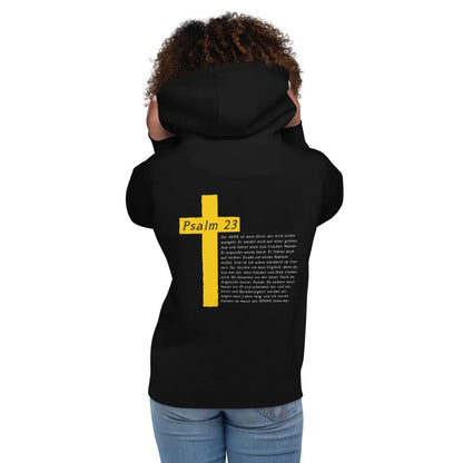 Rückansicht eines Kapuzenpullis mit Kreuzmotiv und Psalm 23, getragen von einer Person, symbolisiert Komfort und spirituelle Botschaft.