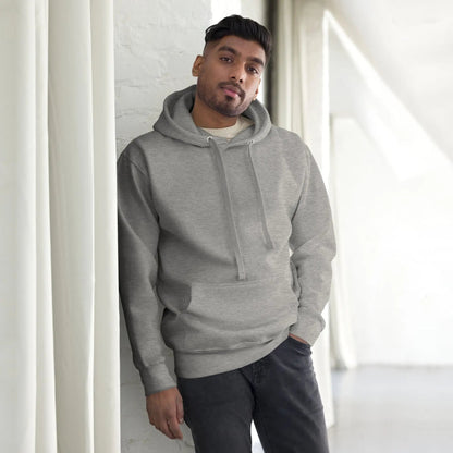 Man wearing a gray hoodie, standing casually indoors, looking towards the camera.