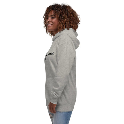 Woman wearing a gray hoodie with "geliebt gerettet" and a cross design, featuring a kangaroo pocket.