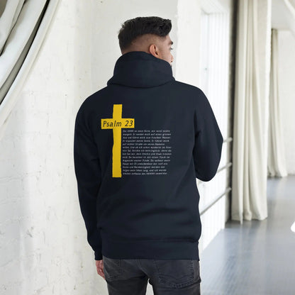 Man wearing hoodie with Psalm 23 and cross design on the back, standing in a modern interior setting.