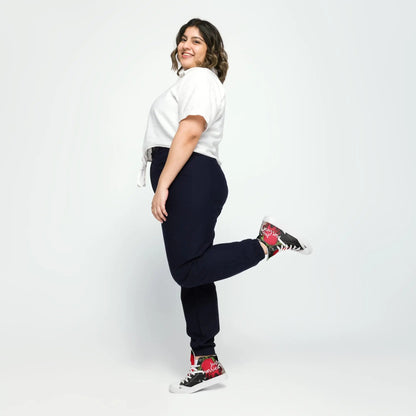 Woman smiling, wearing "Just married" sneakers with floral designs, standing on one foot against a white background.