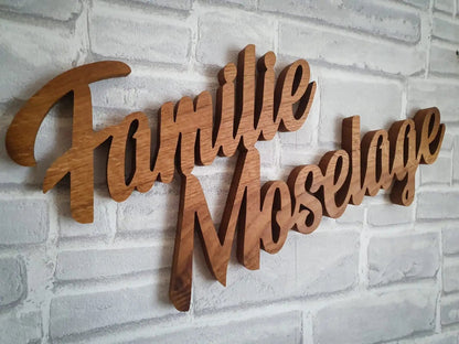 3D Echtholz Familienname an Ziegelwand, dekorativ und personalisiert, perfekt für Innen- und Außenbereich. Kostenloser Entwurf möglich.
