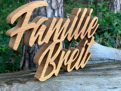 3D wooden family name sign in script font, carved from solid hardwood, suitable for outdoor use, displayed on a rustic wooden surface.