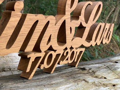 3D Familienname aus Echtholz, personalisiert, 20mm Stärke, für Außenbereich, auf Holztisch platziert, edel und rustikal.