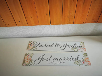 Hochzeitswagen Autokennzeichen mit floralem Design und Schriftzug 'Just married' und Namen.