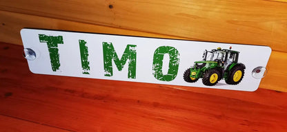 Personalized LKW nameplate with green letters featuring a tractor graphic, mounted with suction cups.