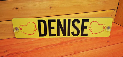 Custom LKW nameplate with 'DENISE' between red heart designs on a yellow background, featuring secure suction mounts.