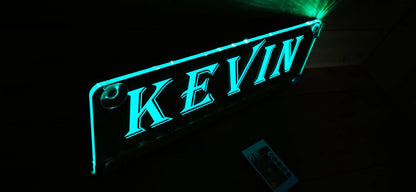 Illuminated LED nameplate with suction cup for trucks, featuring customizable design, shown glowing in a dark setting.