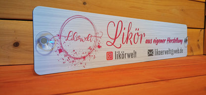 Custom LKW nameplate with suction cups, featuring branding and contact details for "Likörwelt" against a wooden background.