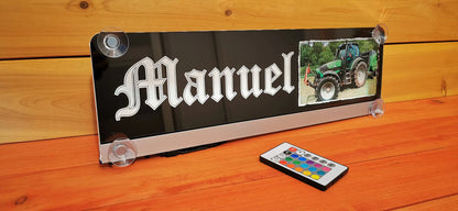 LED LKW Namensschild mit Saugnapf und Fernbedienung, personalisiert mit Motiv und Name in edlem Design, auf Holzoberfläche präsentiert.