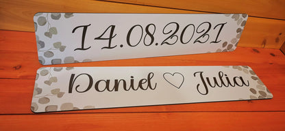 Custom wedding car license plates with date and names on a wood background, perfect for wedding decoration.