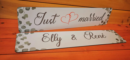 Individually designed wedding car license plates with 'Just Married' and custom names on wood background for photo shoots.