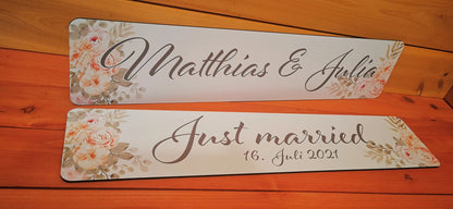 Two custom wedding car license plates with floral design, featuring calligraphy of names and 'Just married 16. Juli 2021'. Perfect for wedding decor.