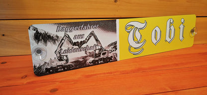 Custom LKW nameplate with 'Tobi' and excavator illustration, printed on aluminum composite with suction cups, displayed on wooden background.