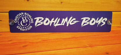 Custom truck nameplate with 'Bohling Boys' in bold white letters on a purple background, mounted with suction cups.