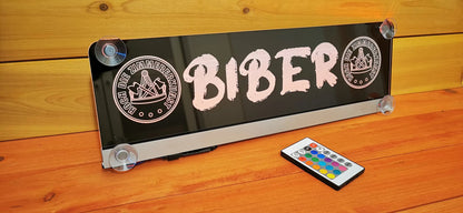 LED truck nameplate with suction cups and custom design, featuring LED lights and remote control on a wooden surface.