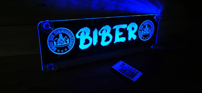 Illuminated LED truck nameplate with "Biber" sign, featuring blue glow and remote control, designed for personalized truck cab decoration.