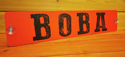 Individuelles LKW Namensschild mit russischem Name 'BOBA' auf roter Hintergrundplatte aus Alu-Verbundmaterial.