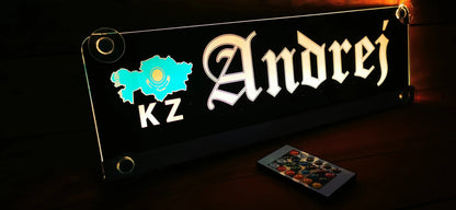Illuminated LED truck nameplate with customizable design displaying 'Andrej' and remote control on a dark background.