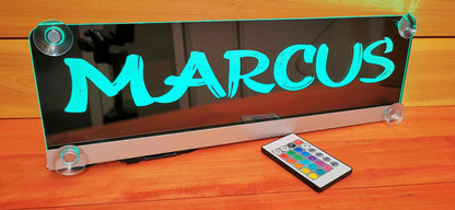 "Custom LED nameplate for truck with suction cups, displaying 'MARCUS' in neon blue, includes remote control for lighting options."