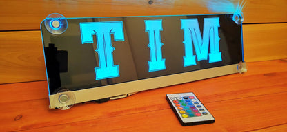 Illuminated LED truck nameplate 'TIM' with suction cups and remote control, ideal for personalized LKW cab decoration.