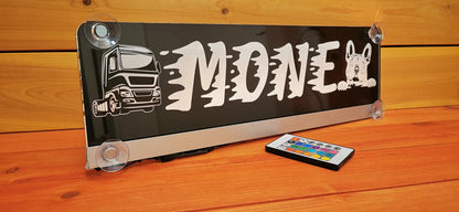 Illuminated LED truck nameplate with suction cups, customizable design, remote control on wooden background.