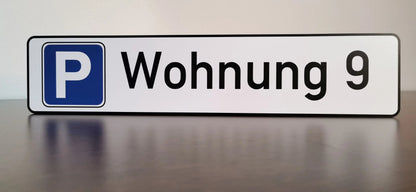 Parkplatzschild mit der Aufschrift 'Wohnung 9' auf einer stabilen Aludibond-Platte, geeignet für langlebigen Außeneinsatz.